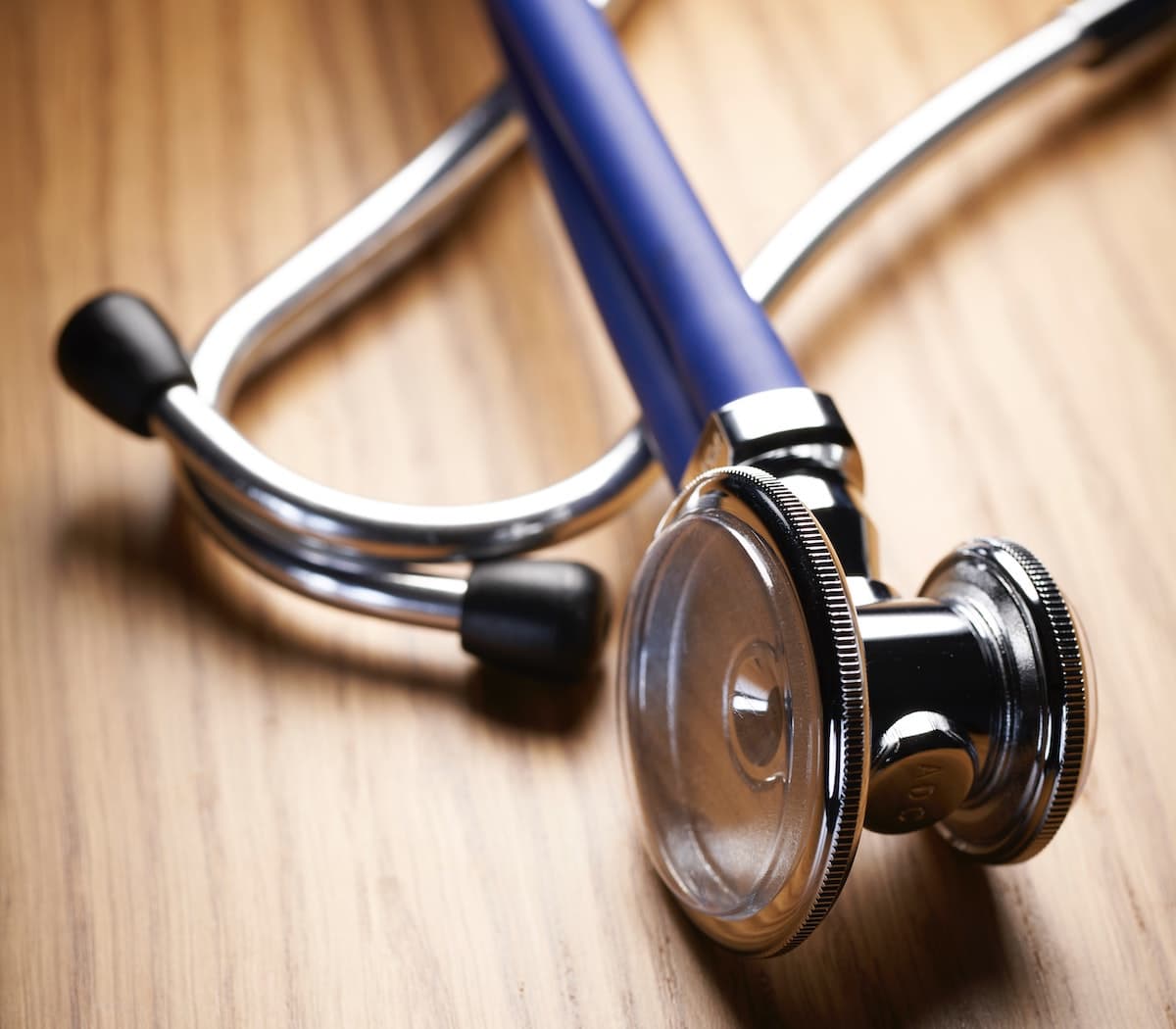 blue stethoscope on a wood surface