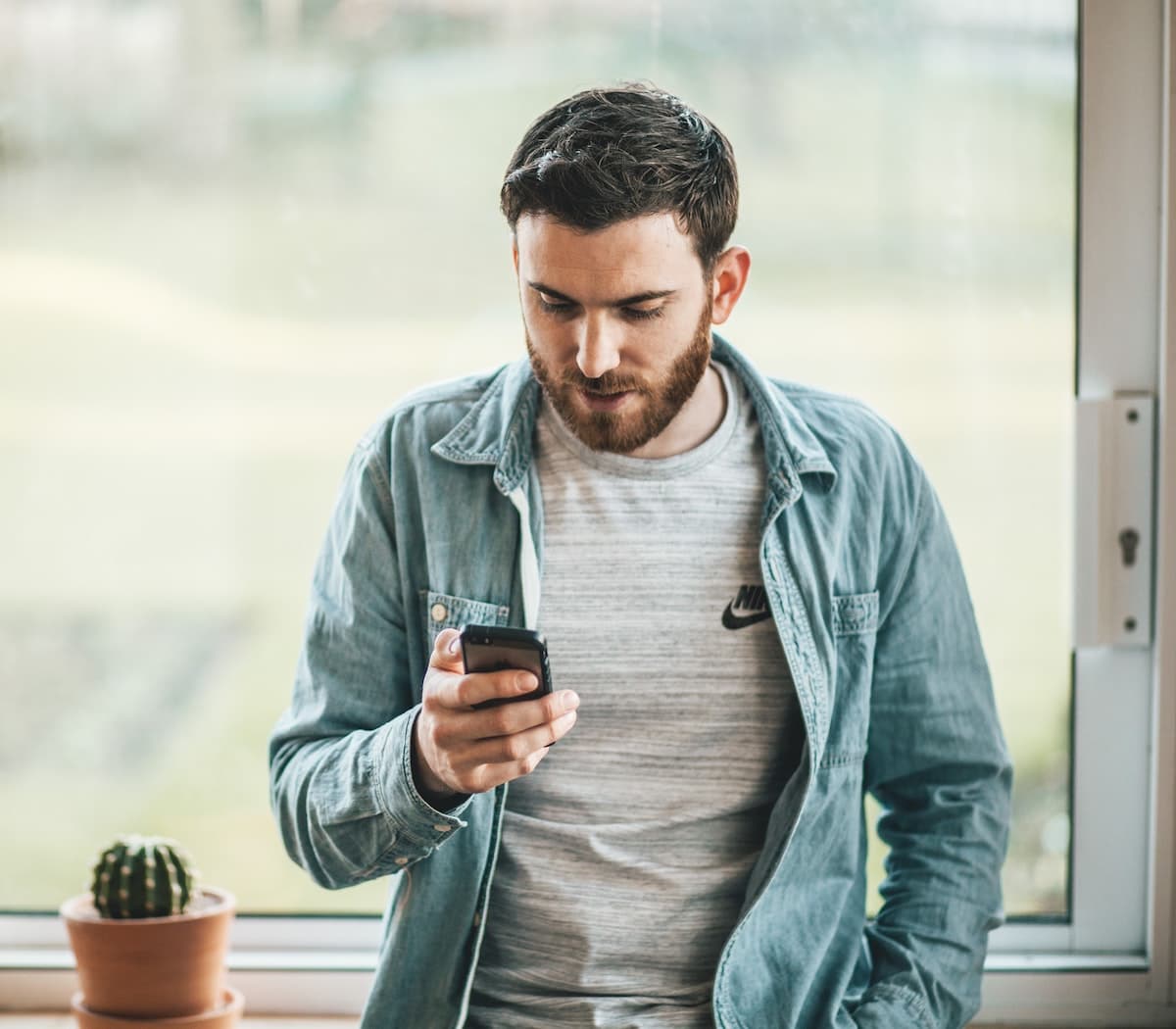 man holding phone reading online reviews